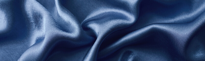 Silver silk background with a folds.  Abstract texture of rippled silk surface, wide long banner