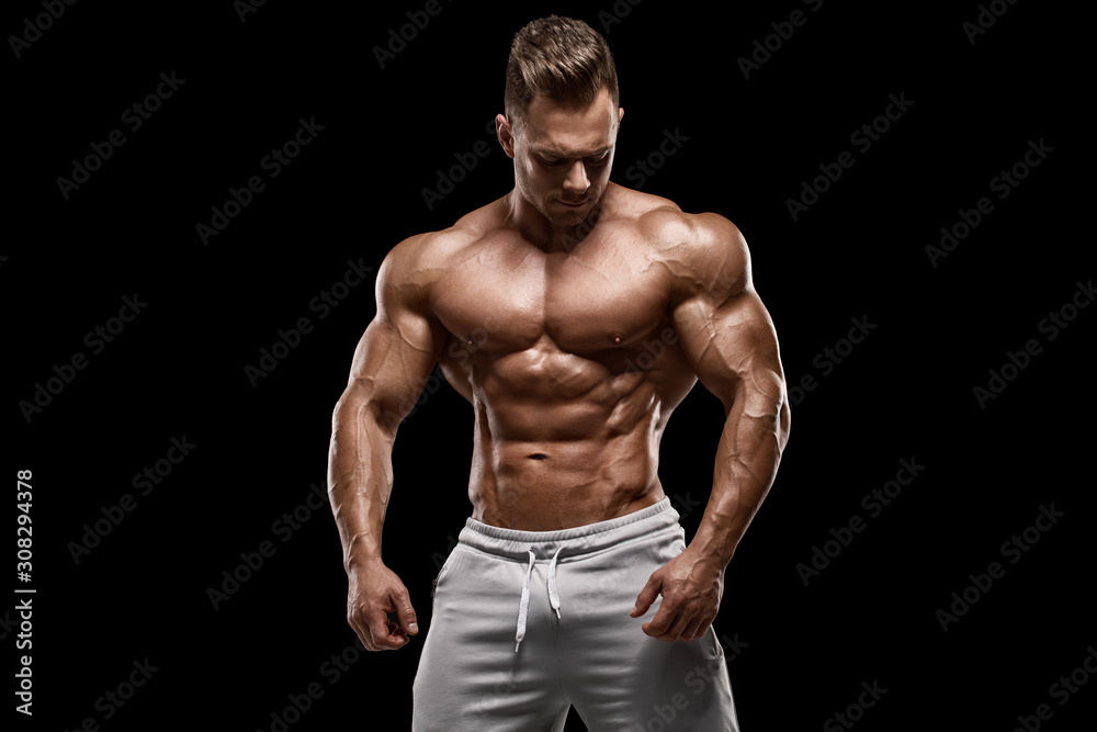 Muscular man showing muscles isolated on the black background. Strong male naked torso abs - obrazy, fototapety, plakaty 