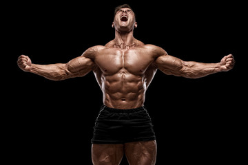 muscular man showing muscles isolated on the black background. strong male naked torso abs