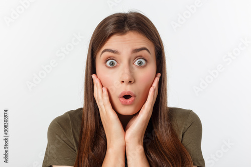 Fotografía Close-up portrait of surprised beautiful girl holding her head in amazement and open-mouthed