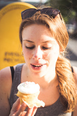 Portrait of a young woman eating a cupcake