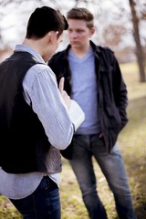 Wall Mural - Vertical shot of two male standing and talking about the bible