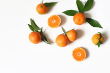 Styled Stock Photo. Decorative Summer Fruit Composition. Whole And Sliced Orange Tangerines, Citrus Fruit And Leaves Isolated On White Table Background. Food Pattern. Empty Space. Flat Lay, Top View.