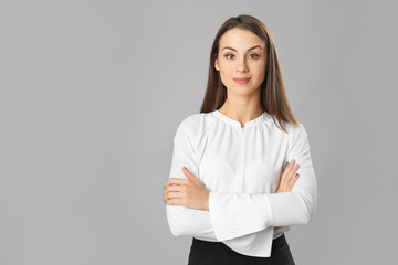 Beautiful young businesswoman on grey background