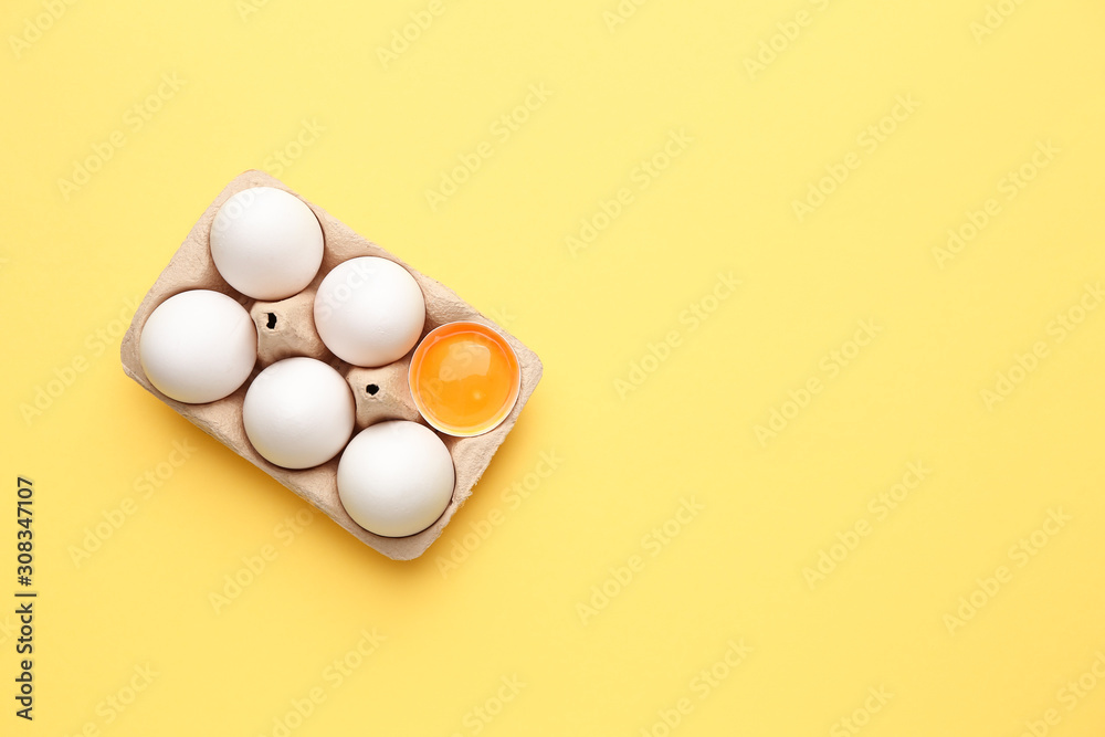 Box with fresh raw eggs on color background