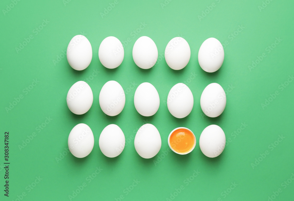 Broken egg among whole ones on color background. Concept of uniqueness