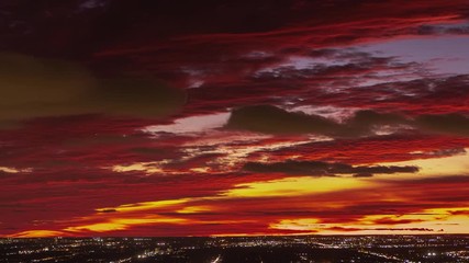Wall Mural - a vertical panning cityscape timelapse with a sky on fire type of sunset with red orange, pink and y