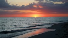 A Beautiful Full Sunset Over Breaking Ocean Waves On Gulf Of Mexico Florida Beach On A Vacation By The Sea Is Featured In This One Minute Long Video Footage