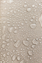 Texture Of Water Drops On Fabric Textile Close-up. Rain Background In Beige Color. Waterproof Surface Abstract. 