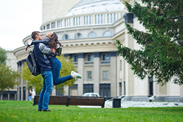 Beautiful romantic couple in love havin fun on background of the architecture of the city of Novosibirsk, Russia. Woman and man hugging