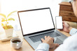 © panitan - mockup image blank screen computer,cell phone with white background for advertising text,hand man using laptop texting mobile contact business search information on desk in office.marketing and design