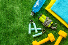 Sport Equipment For Self-development. Composition With Dumbbells On Green Gress Background Top-down Frame Copy Space