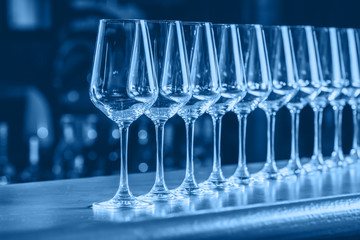 Wine glasses in a row. Buffet table celebration of wine tasting. Nightlife, celebration and entertainment concept. Horizontal, cold toned image