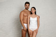 © New Africa - Young couple in white underwear near brick wall