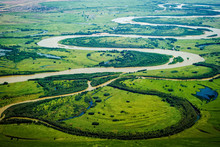 View Of The Valley Of A Meandering River Among Green Fields And Forests. Aerial Photography