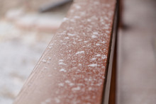 First Snow Lies On Wooden Railing Closeup