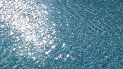 Wall Mural - water rippled pattern on blue water surface in swimming pool with sunlight reflected.