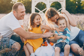 Wall Mural - portrait of a lovely big family having fun outdoor while mother father and sister is tickling her li