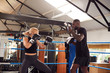 Male Personal Trainer Sparring With Female Boxer In Gym Using Training Gloves
