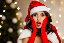 Beautiful Sexy Excited Girl Wearing Santa Claus Clothes On The Background Of The Christmas Tree. Copy Space