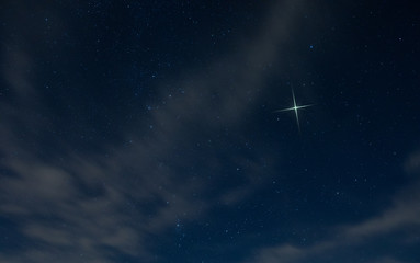 christmas star rising in north carolina with light clouds in the night sky.