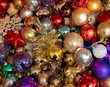 Collection of multicoloured Christmas baubles and tinsel for decorating a Christmas tree. The decorations are cheap and old, and are stored jumbled together