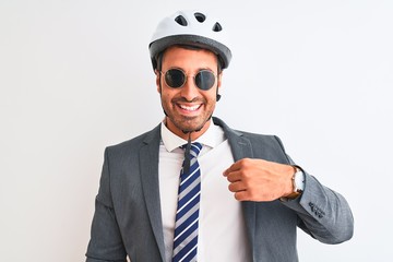 Canvas Print - Young handsome business man wearing bike helmet and sunglasses over isolated background with surprise face pointing finger to himself