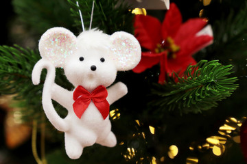 Wall Mural - White toy rat hanging on christmas tree on festive decorations background. Festive card, Chinese New Year of Pig, Zodiac symbol 2020