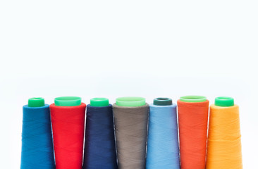 Colorful bobbin thread isolated on white background.