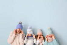 Happy Family In Winter Clothes On Color Background