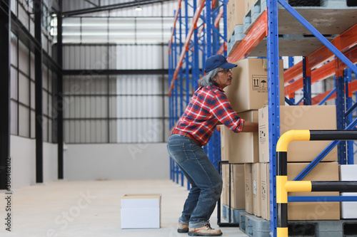 Fotografía Asian worker man hurt his back .lift heavy box in factory