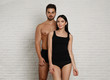 © New Africa - Young couple in black underwear near white brick wall