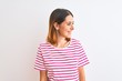 © Krakenimages.com - Beautiful redhead woman wearing casual striped pink t-shirt over isolated background looking away to side with smile on face, natural expression. Laughing confident.