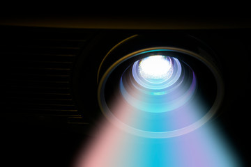 A colors beam from projector machine for presentation in the dark room