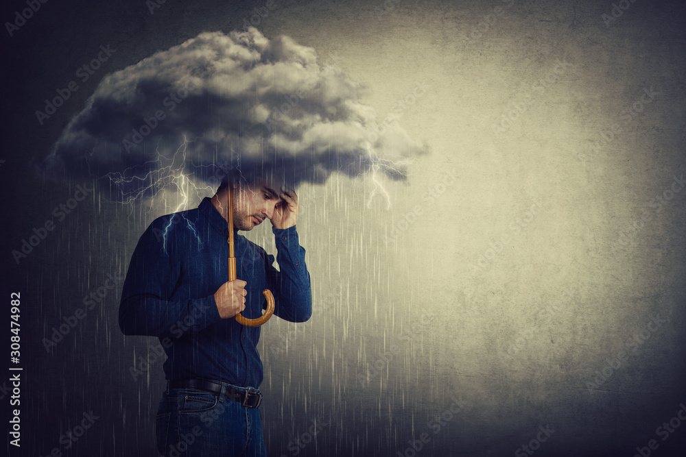Pessimistic man, standing under rain, suffering anxiety as holding an umbrella thunderstorm cloud over head. Concept of memory loss and dementia disease. Alzheimer's losing brain and memory function. - obrazy, fototapety, plakaty 