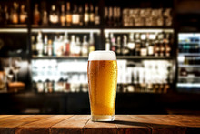 Glass Of Beer On Wooden Board And Blurred Bar Background.Free Space For Your Decoration. 