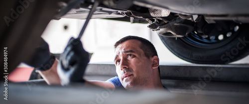 Cuadros en Lienzo Auto mechanic repairer checking condition under car on vehicle lift