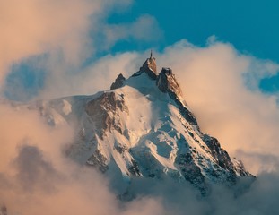 Wall Mural - Picture of Aiguille du Midi covered in the snow and the fog under a blue sky in the French Alps