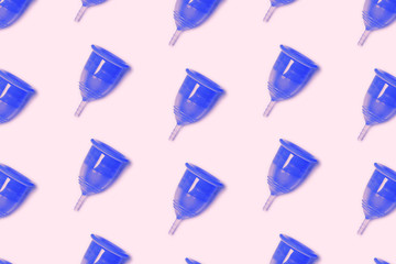 Trendy pattern of blue eco menstrual cup on a pink background. The symbolic image of women's special days. Zero waste concept, eco-friendly lifestyle, reduced consumption