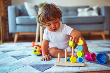 Wall Mural - Beautiful toddler child girl playing with toys on the carpet