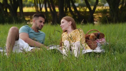 Wall Mural - Happy young couple in park, slow motion effect. Picnic time