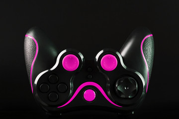 Sticker - Black game controller gamepad with pink buttons on black background upside down close up.