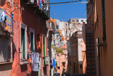 Fototapeta Londyn - Panoramic view of beautiful Procida on a sunny summer day. Colorful cafes, houses and restaurants, fishing boats and yachts, clear blue sky and the azure sea on the island of Procida, Italy. Napoli