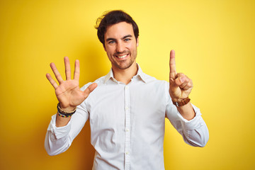 Sticker - Young handsome businessman wearing elegant shirt standing over isolated yellow background showing and pointing up with fingers number six while smiling confident and happy.