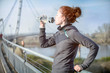 © Westend61 - Young woman drinking water out of a bottle after jogging