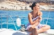 © Krakenimages.com - Young beautiful woman smiling happy, sailing on a boat on a sunny day on holidays