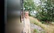 © Cavan Images - over 60's portrait of a female camping in a camper van in summer
