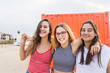 © Cavan Images - Three young happy teenage girls have fun against orange wall