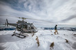 © Cavan Images - Helicopter pilot explores a snow-covered mountain summit.