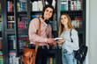 © Тарас Нагирняк - Happy students couple in library have discussion about book.